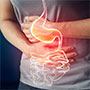 Illustration of digestive system over man holding stomach